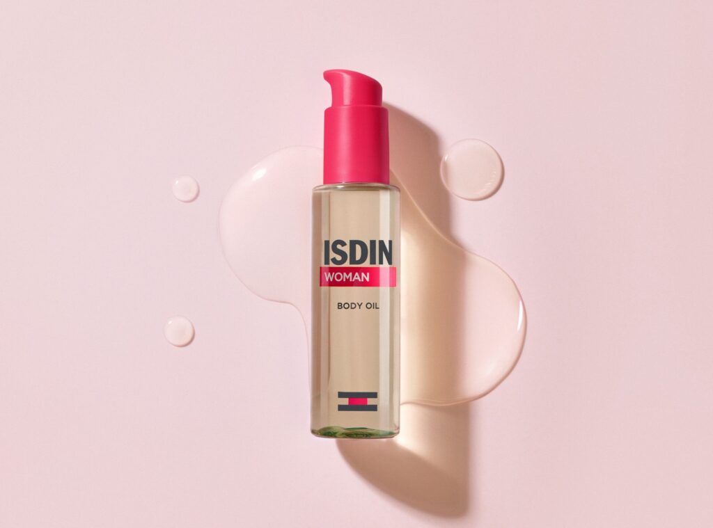 Frasco do novo ISDIN Woman Body Oil em fundo neutro