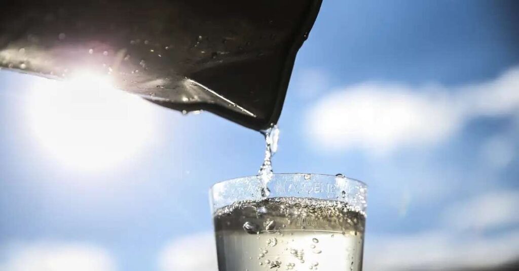 Mulheres coletando água em uma fonte rural