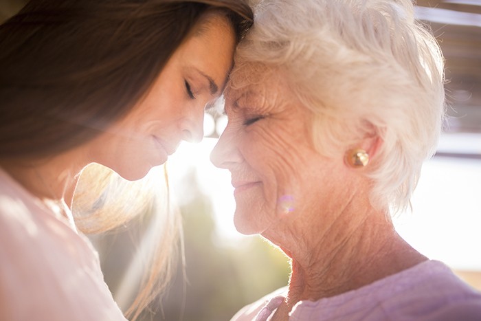 Pessoa cuidando de um idoso com preocupação e empatia