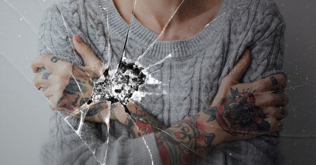 Mulher olhando para o espelho com expressão de dúvida e reflexão aos 40 anos