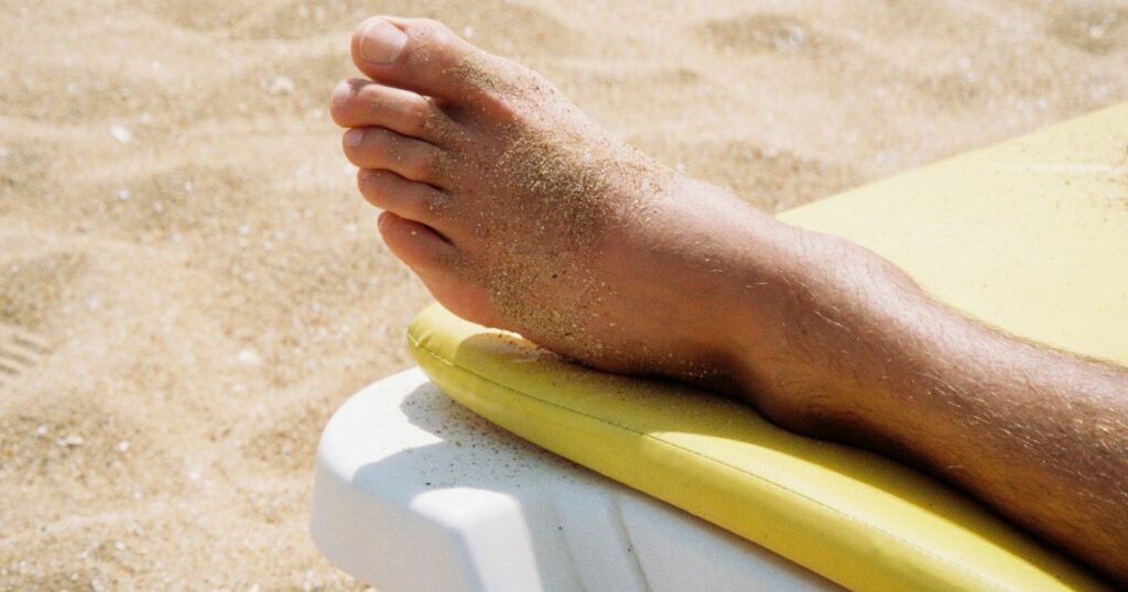 Pessoa com as pernas elevadas em um ambiente fresco para aliviar o inchaço durante o calor